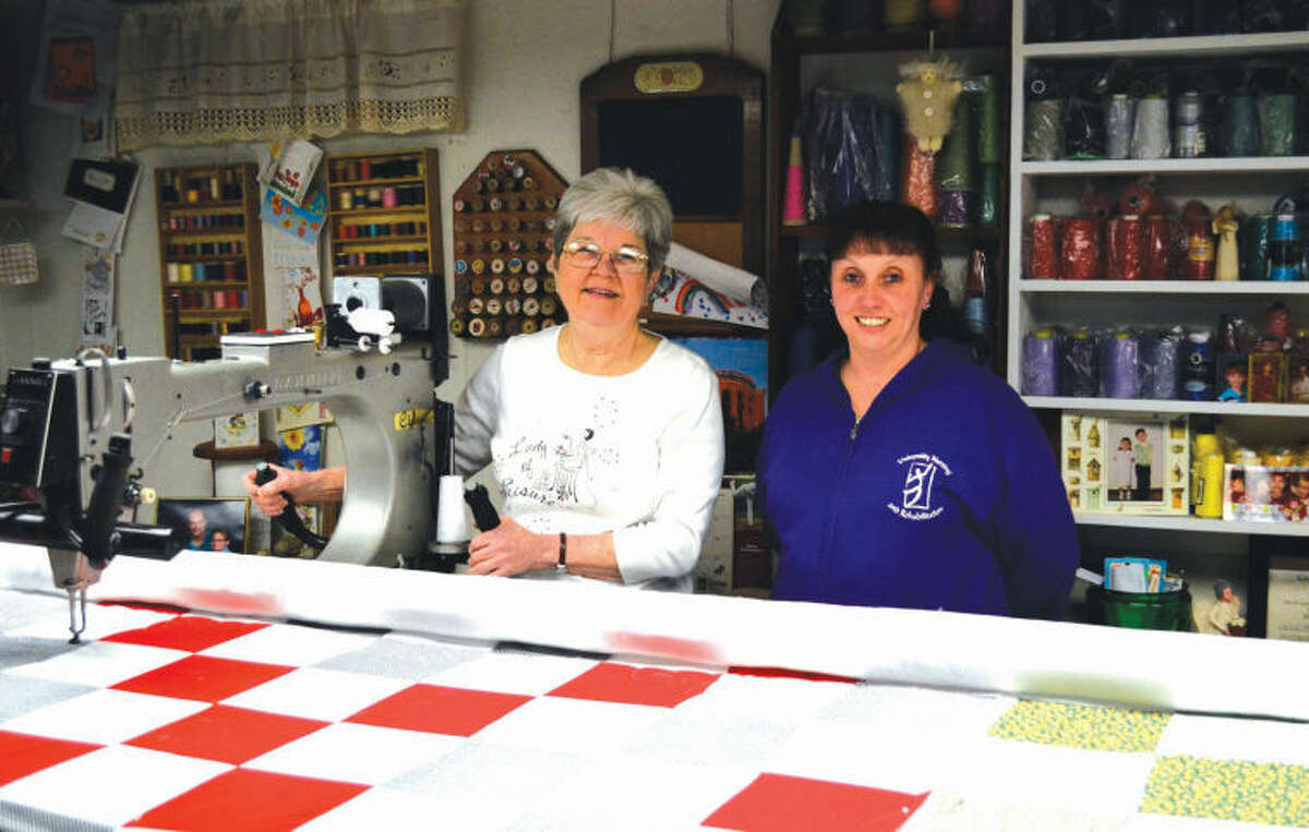 Bettye Smith, left, shows Wanda Howell, activities director for University Nursing and Rehabilitation Center, her the Gammill quilting machine she uses to make quilts. Smith also presented Howell with 10 quilts to take back to the nursing home. 
