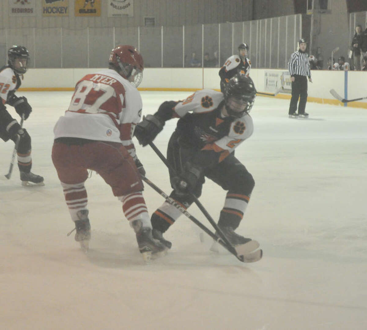 EHS junior Drew Lewis battles with an Alton defender for the puck during the first period. 