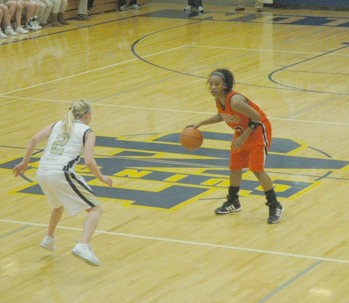 Edwardsville's Lauren White sets up the offense with Quincy Notre Dame's Shannon Foley watching her closely.