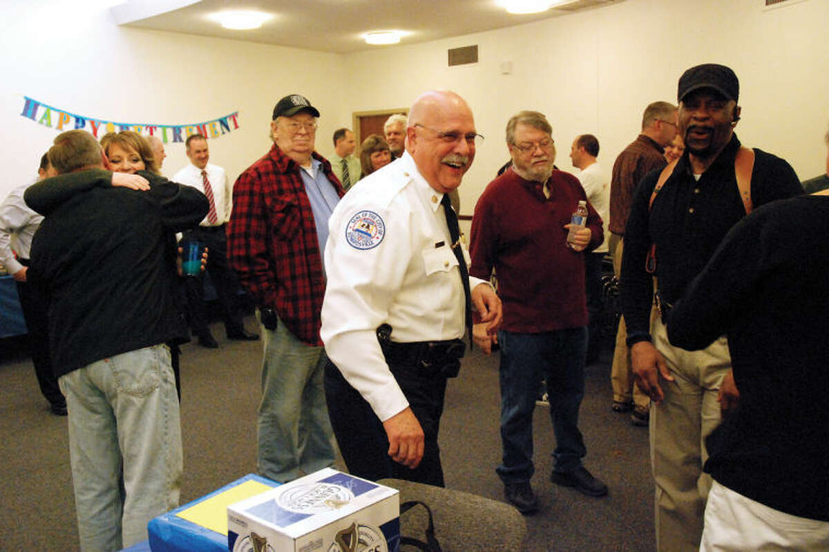 Edwardsville Police Major Don Lask, in uniform, visits with friends a farewell party conducted in his honor Thursday.