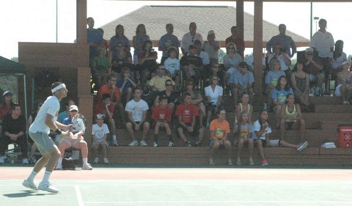 Devin Britton prepares to receive a serve while a contingent of fans looks on intently during the doubles finals on Sunday at the EHS Tennis Center.
