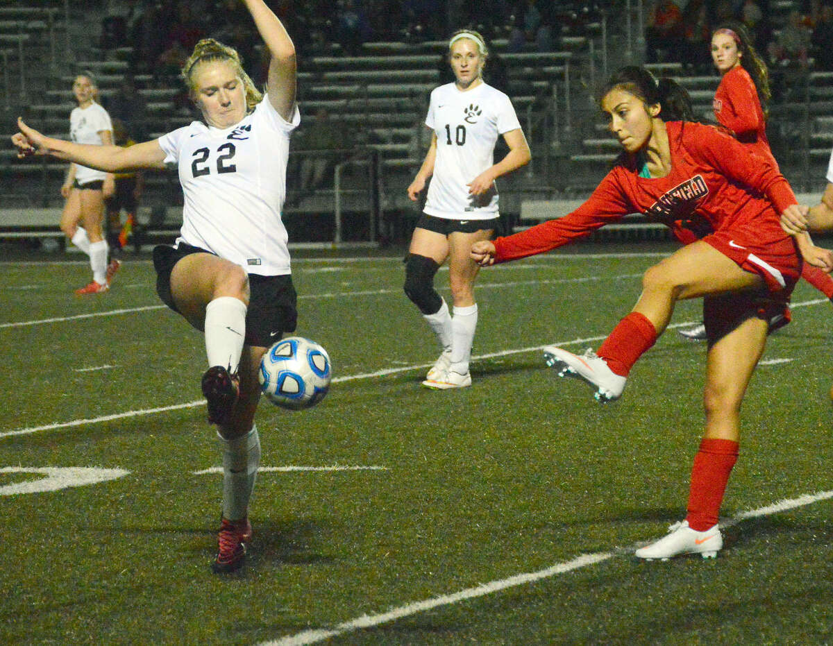 Edwardsville junior back Taylor Hansen, left, blocks a clearing attempt from a Springfield player during second-half action at the District 7 Sports Complex in the Metro Cup Opener on Monday. 