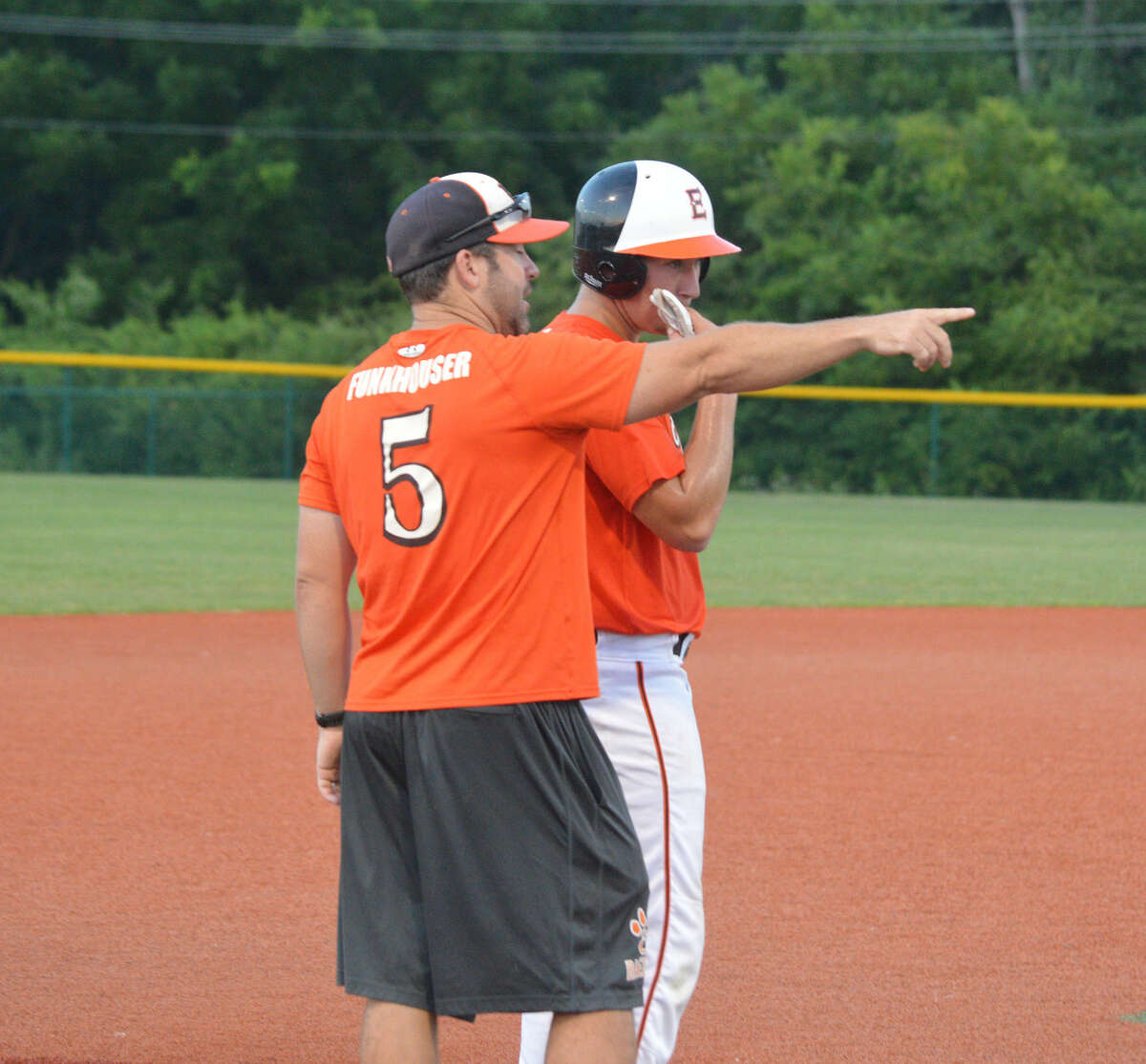 Tigers coach Tim Funkhouser talks to Daniel Reed after Reed reached third base in the fourth inning.