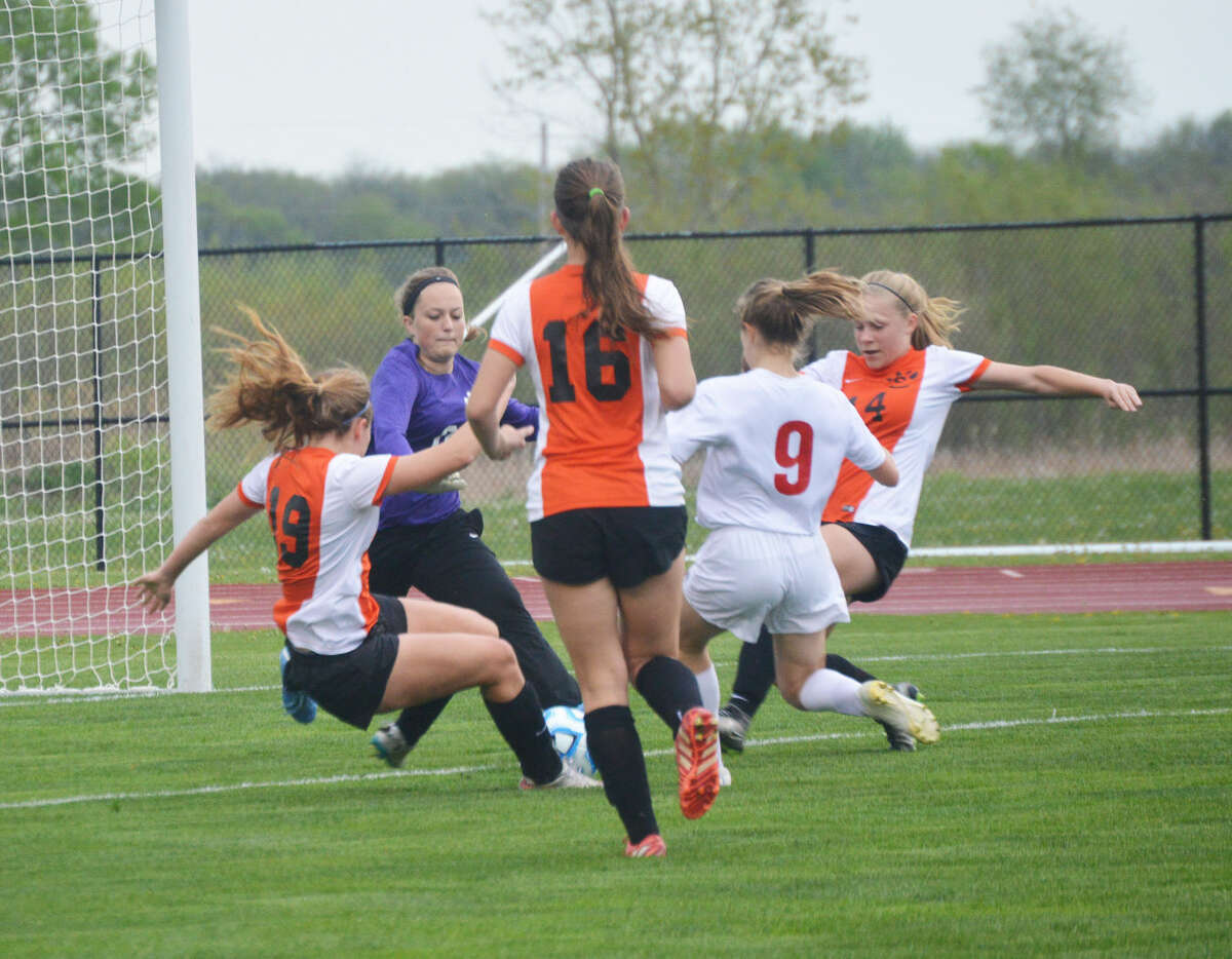 The Edwardsville defense of Jane Ann Crabtree, left, keeper Marissa Bogner, second to left, Allysiah Belt, third to left, and Sarah Krause, right, scramble after a loose ball.