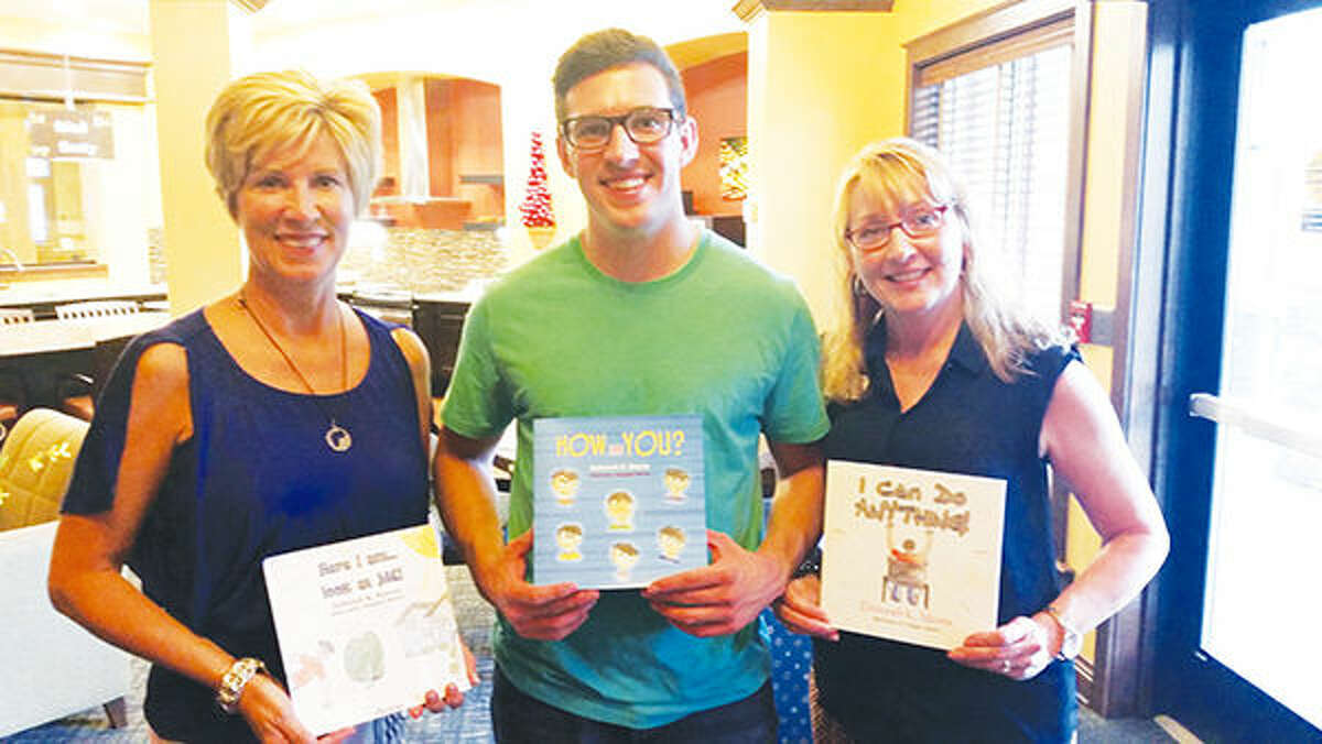From left are: African Vision of Hope Founder and President Judy Bertels, Illustrator Douglas Morris, and Author Debbie Morris, display Debbie's three published children's books. The fourth book is being donated to 2,000 children in Sub-Saharan Africa.