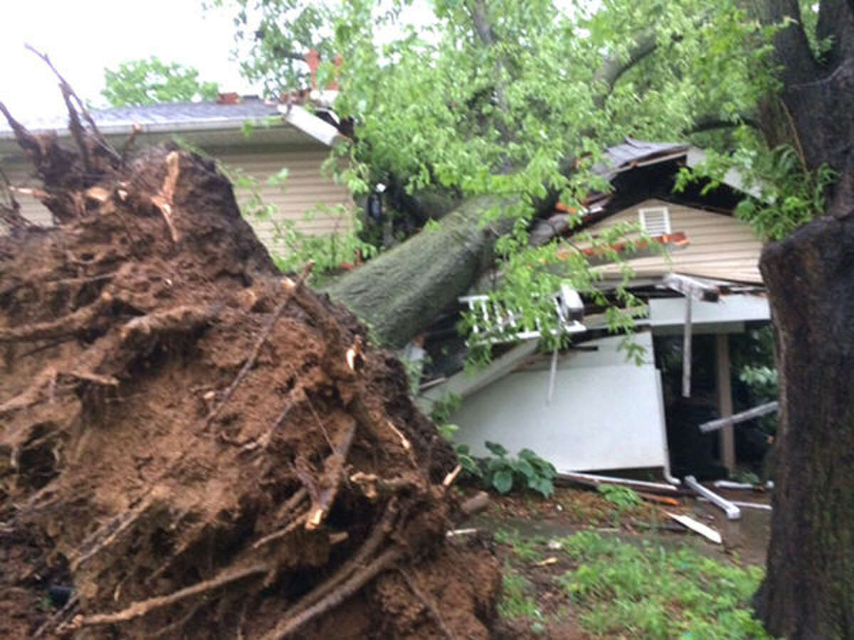 An uprooted tree rests on the roof of a home at 130 Bollinger in Glen Carbon following Saturday's storm.