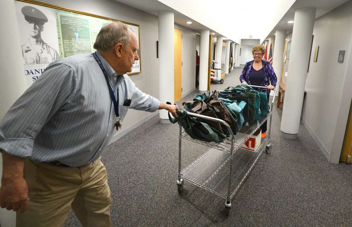 City of Norwalk's Stuart Wells, Democratic Registrar of Voters and Karen Doyle Lyons, Republican Registrar of Voters move a cart with all the moderators bags down a hallway at City Hall for moderator training on Monday April 25 2016