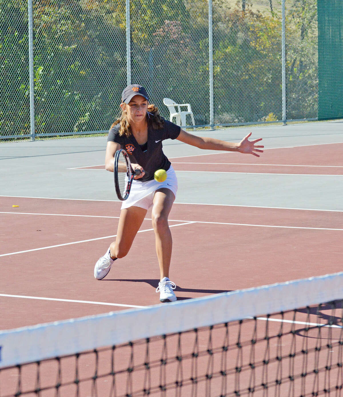 Edwardsville junior Maria Mezo hits a forehand shot at the net during her doubles match in the Alton Sectional.