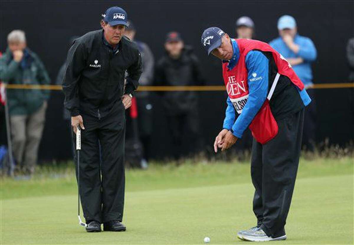 Phil Mickelson of the United States with his caddie Jim McKay line up his putt on the 5th green during the second round of the British Open Golf Championship at the Royal Troon Golf Club in Troon, Scotland, Friday, July 15, 2016. (AP Photo/Peter Morrison)