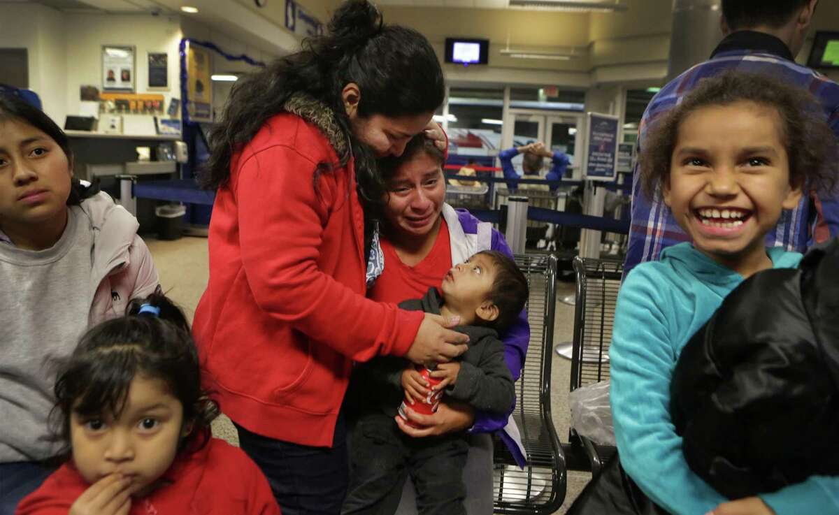 Lisvette Sanches Rodriguez, center, of El Salvador, comforts a grateful Vina Lopez, of Guatemala, with her two year old son, after a group of 11 immigrants from Central America were given food and clothing by members of the Interfaith Welcome Coalition, following their release from the Karnes County Residential Center. The Interfaith Welcome Coalition also found housing for them so they didn't have to spend the night at the San Antonio bus station where they were dropped off without food or money by the Residential Center. At right is Marilin Lopez Figueroa, 8, and at left is Sindy Cotoc Otzoy de Siguin and her 4 year old daughter Heidy. Thursday Dec. 18, 2014.