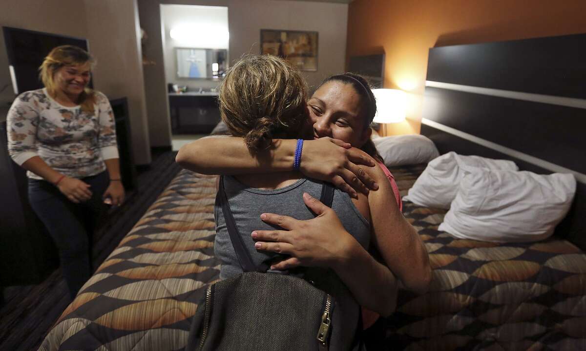 Lichter Immigration Founder and Managing Partner Laura Lichter (back to camera) hugs Katherine Christel Ponce Osorio, 24, of El Salvador, as Roxana Maldonado, 21, of Honduras, (left) looks on after Ponce and Maldonado with their daughters were released from the Dilley detention center Thursday June 11, 2015 in Dilley, Tx.