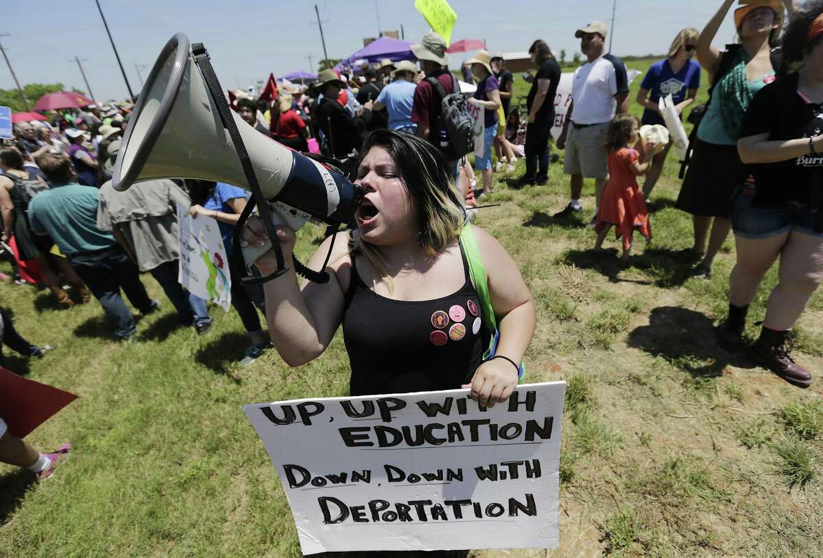 Chasity Valerio yells into a bull horn during the immigrant detention center march and protest in Dilley, Texas on Saturday, May 2, 2015. (Kin Man Hui/San Antonio Express-News)