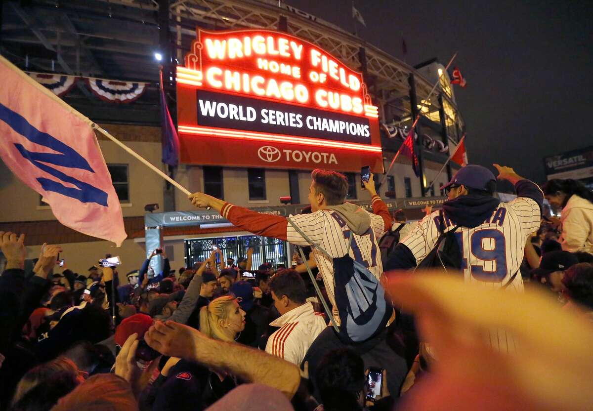 Chicago Cubs fans celebrate in front of Wrigley Field in Chicago on Wednesday, Nov. 2, 2016, after the Cubs defeated the Cleveland Indians 8-7 in Game 7 of the baseball World Series in Cleveland. (AP Photo/Charles Rex Arbogast)