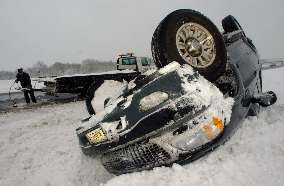 Dec. 25-26, 2002 and Jan. 3-4, 2003: Tow truck operator Jason Lorenz prepares to right a flipped four-wheel drive vehicle on the Northway during the second nor'easter in as many weeks on Jan. 4, 2003.