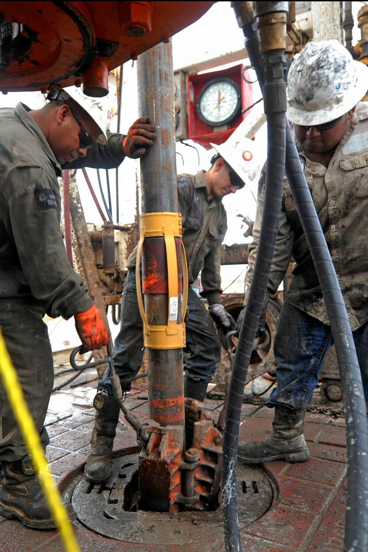 Floor hands put casing downhole on Trinidad Drilling Rig 433 on Wednesday, Nov. 2, 2016, in Midland County. James Durbin/Reporter-Telegram
