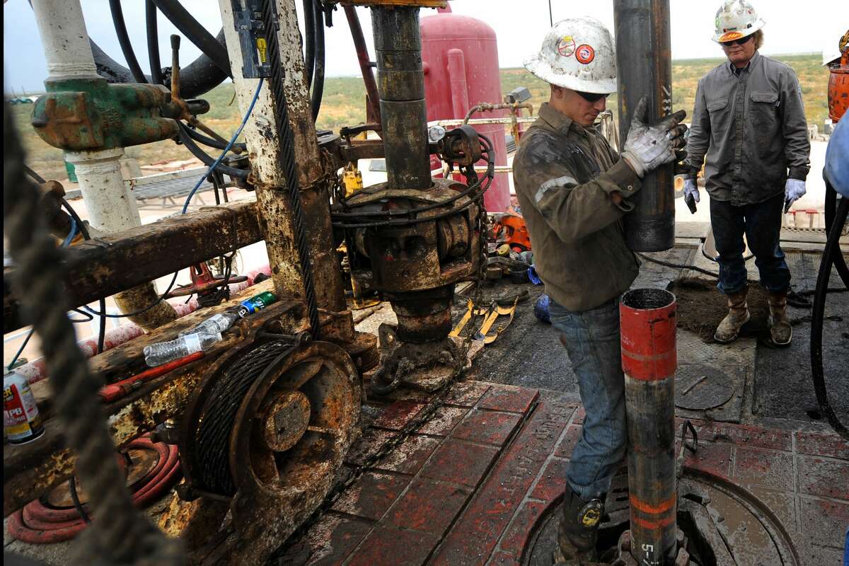 Noe Olvera connects a section of casing on the floor of Trinidad Rig 433 on Wednesday, Nov. 2, 2016, in Midland County. James Durbin/Reporter-Telegram