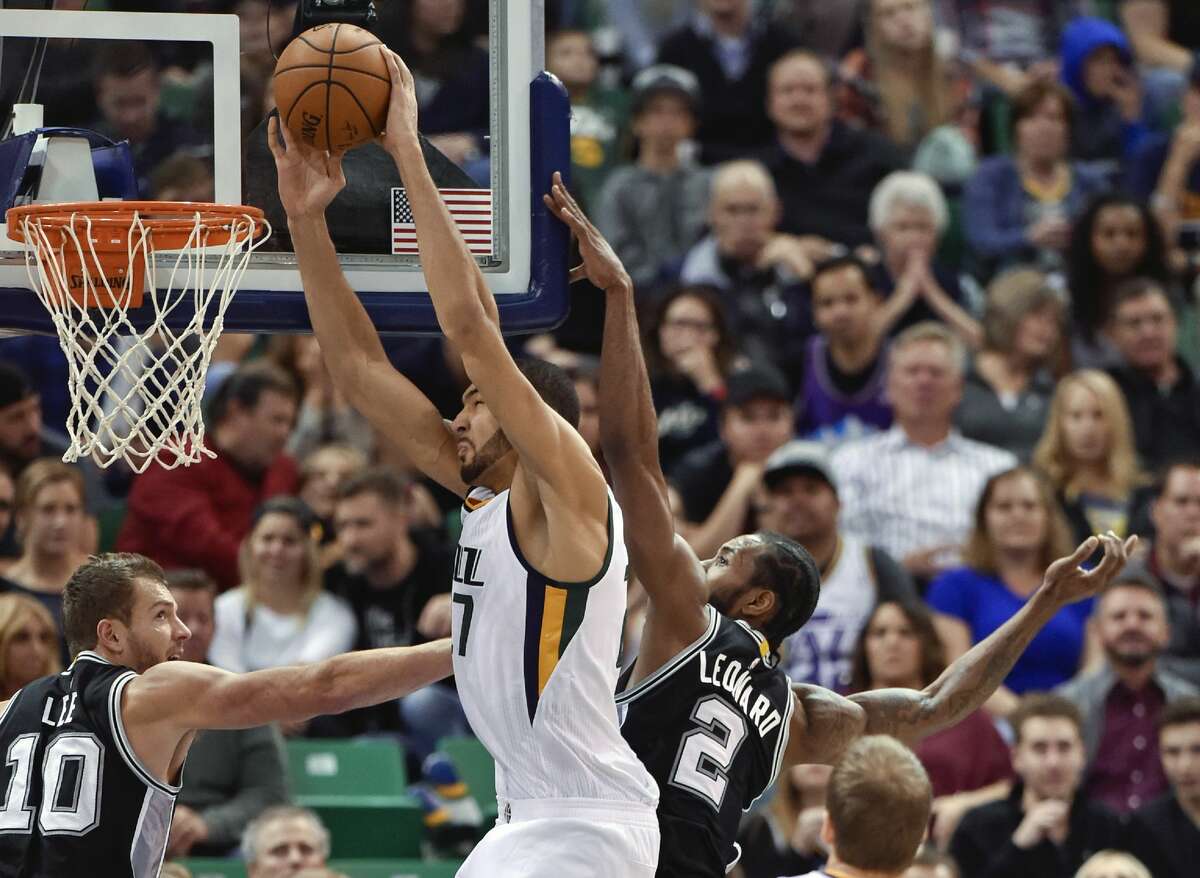 SALT LAKE CITY, UT - NOVEMBER 04: Rudy Gobert #27 of the Utah Jazz goes to the basket between the defense of David Lee #10 and Kawhi Leonard #2 of the San Antonio Spurs in the second half of the Spurs 100-86 win at Vivint Smart Home Arena on November 4, 2016 in Salt Lake City, Utah. NOTE TO USER: User expressly acknowledges and agrees that, by downloading and or using this photograph, User is consenting to the terms and conditions of the Getty Images License Agreement. (Photo by Gene Sweeney Jr/Getty Images)