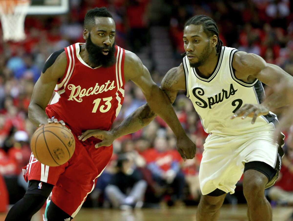 Rockets guard James Harden (13) is guarded by Spurs forward Kawhi Leonard in the first half at the Toyota Center on Dec. 25, 2015, in Houston.