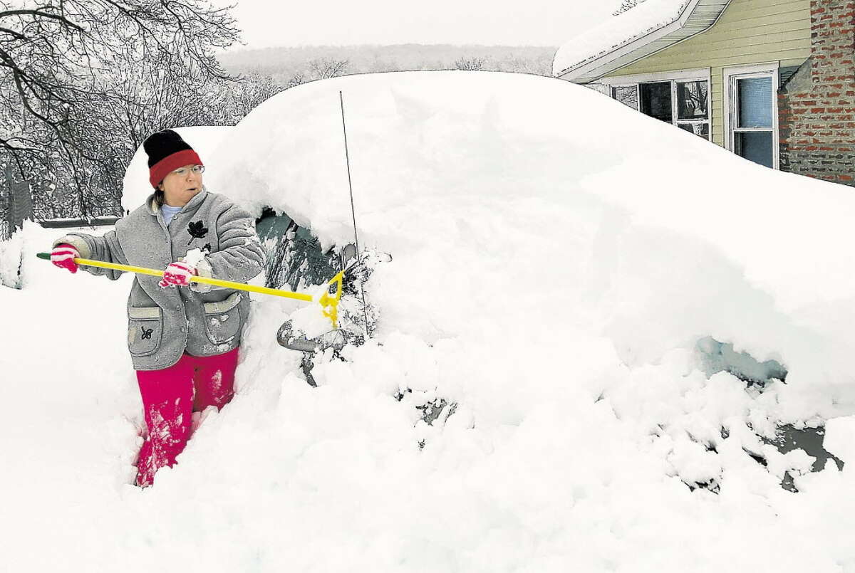 February 2010: The hilltowns received upwards of two feet of snow from the first part of a two-part snowstorm. Diane Wells attempts to clear a car buried in the snow on Wednesday, Feb. 24, 2010, at Warner Lake in East Berne.