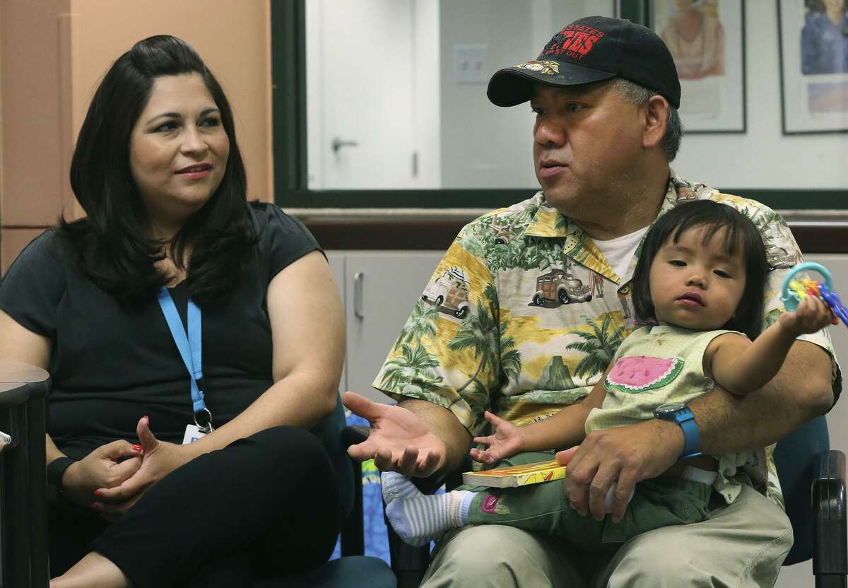 Michelle Alvarado (left) is a caseworker who has been helping Eli Lequang, who was a Marine and is now a single parent raising his 1-year-old daughter, Kayleen, after his wife died. Trained educators like Alvarado go into the homes of caregivers to provide guidance and help with parenting skills, as well as ladle on social services that reduce parental stress and benefit children