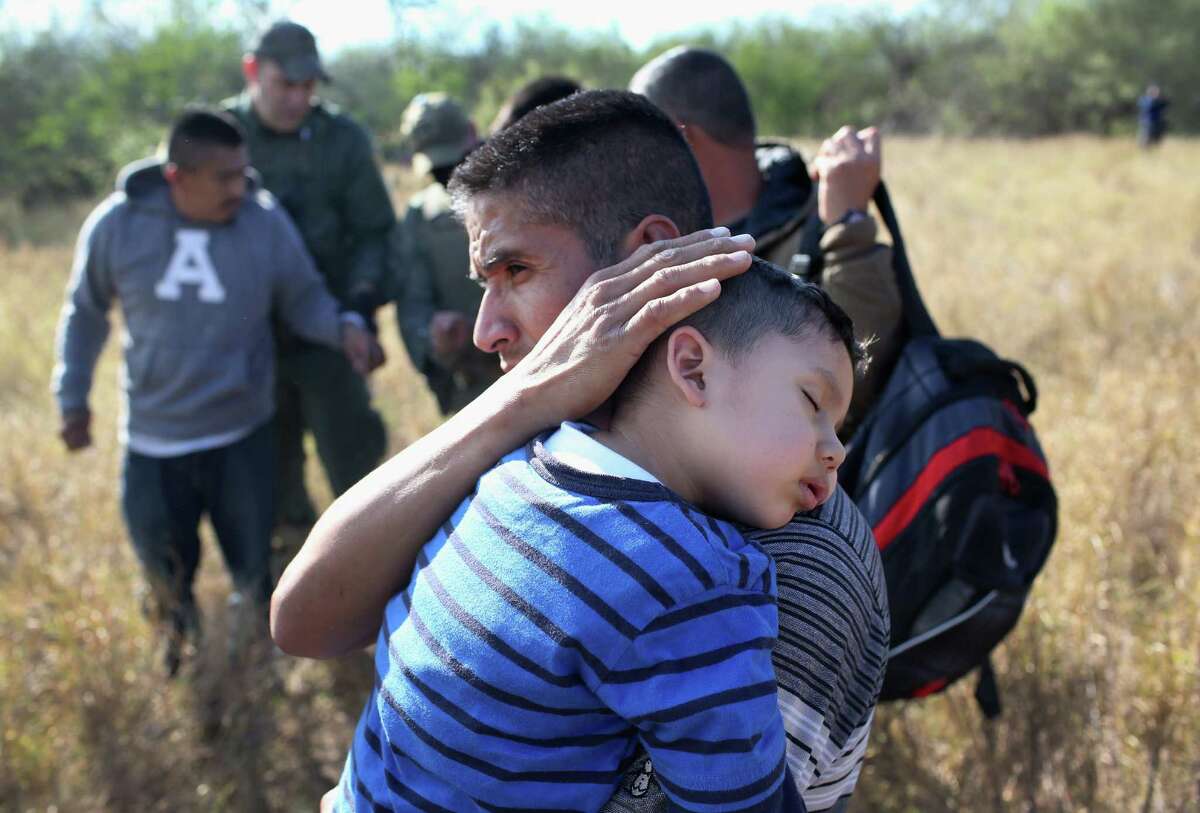 A father holds his sleeping son, 3, after they and other undocumented immmigrants were detained by Border Patrol agents on December 7, 2015 near Rio Grande City, Texas. They had just illigally crossed the U.S.-Mexico border, and he said he was bringing his family from Guanajuato, Mexico to settle in San Antonio, Texas. The number of migrant families and unaccompanied minors crossing the border has again surged in recent months, even as the total number of illegal crossings nationwide has gone down from the previous year. (Photo by John Moore/Getty Images)