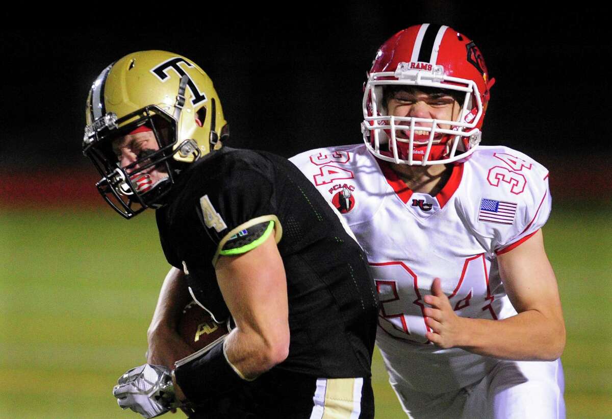 New Canaan's Sam Gilman, right, comes in from behind to tackle Trumbull's Danny Hoffmann during high school football action in Trumbull, Conn. on Friday Nov. 4, 2016.