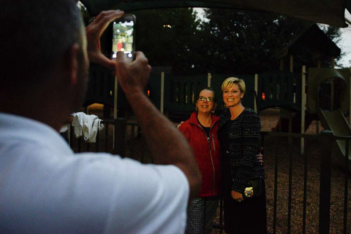 State Rep. Jim Murphy takes a photo Tuesday of State Rep. Sarah Davis, right, with supporter Lisa White Watkins outside the Colonial Park Recreation Room.﻿