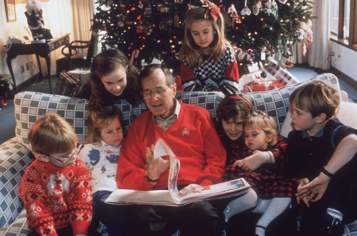 24th November 1991: American statesman George Bush, the 41st President of the United States, reading a Christmas story to his grandchildren on Christmas Eve at the White House, Washington DC. (Photo by Susan Biddle/Keystone/CNP/Getty Images)
