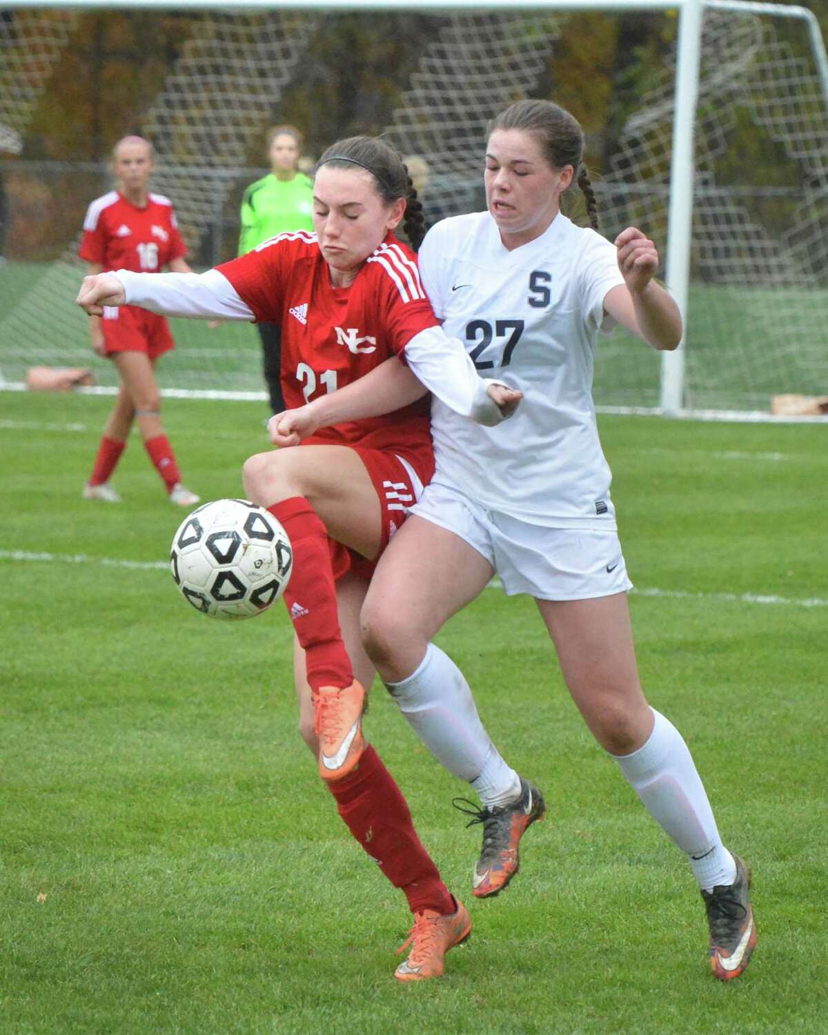 Staples’ Charlotte Rossi (27) battles New Canaan's Julia Ozimek (21) during a Class LL girls soccer second-round game at Staples High School on Wednesday in Westport.