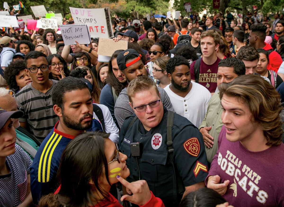 Protester Patricia Romo, left, 22, argues with Trump supporter Cody Williams, 18, during a demonstration at Texas State University in San Marcos, Texas, Thursday Nov. 10, 2016, opposition of Donald Trump's presidential election victory. (Jay Janner/Austin American-Statesman via AP)