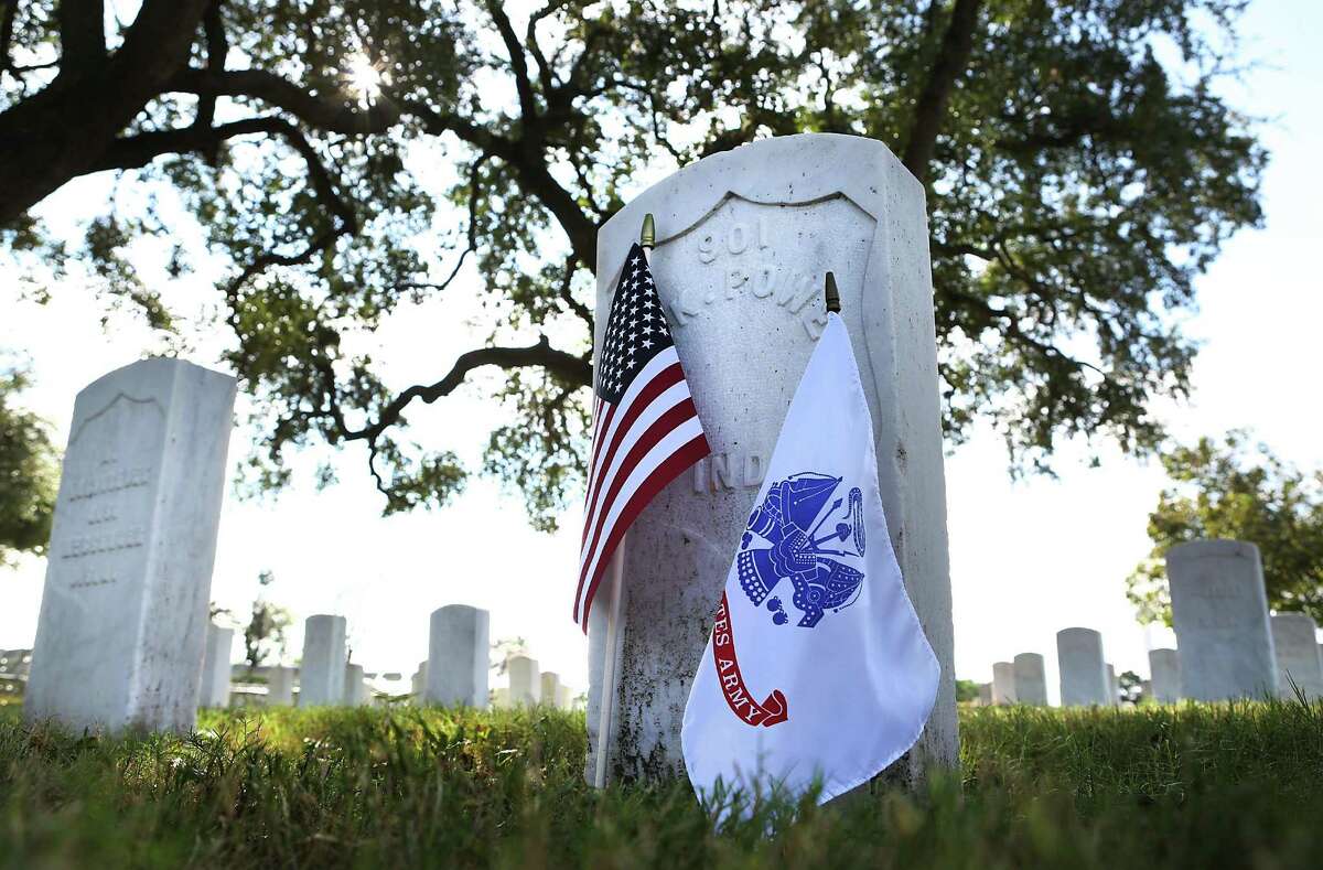 An Army and American flag adorn the grave of James K. Powers of Indiana who died in 1914, at the San Antonio National Cemetery. A Veterans Day Commemorative Ceremony presented by the Bexar County Buffalo Soldiers was held at the site, Friday, Nov. 11, 2016.
