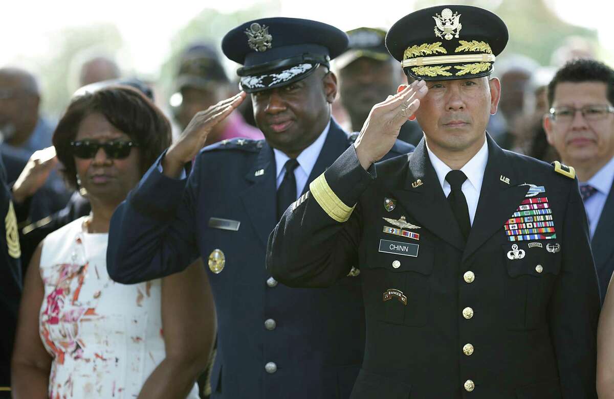 Maj. Gen. K.K. Chinn, U.S. Army South Commanding General, right, and Maj. Gen. Mark Anthony Brown, Vice Commander, Air Education and Training Command in the U.S. Air Force, salute as the colors are retired during a Veterans Day Commemorative Ceremony presented by the Bexar County Buffalo Soldiers at San Antonio National Cemetery on Friday, Nov. 11, 2016. Gwen Brown, wife of Maj. Gen Brown is at left.