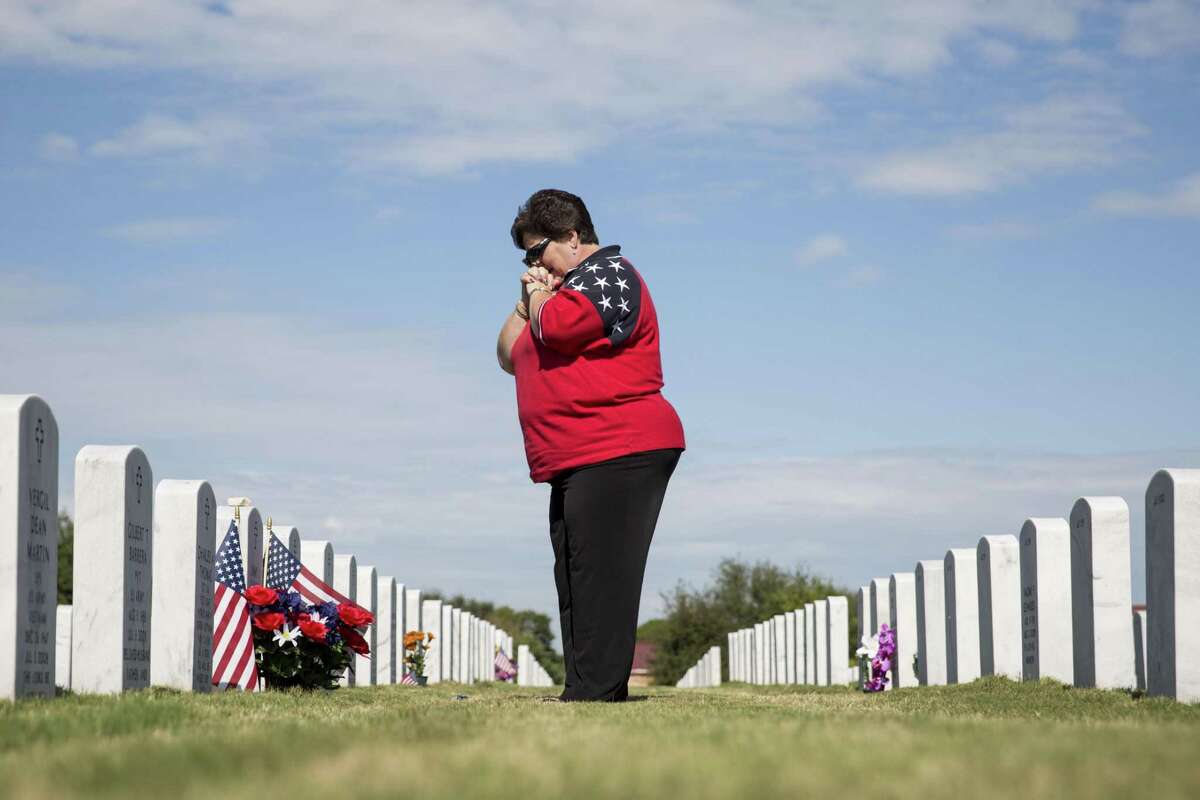 Judy Carlile visits her husband's headstone after the Veterans Day ceremony at Fort Sam Houston National Cemetery in San Antonio, Texas on November 11, 2016. Her husband Jim Carlile was a Vietnam veteran who spent 23 years in the Air Force, but passed away eight years ago.