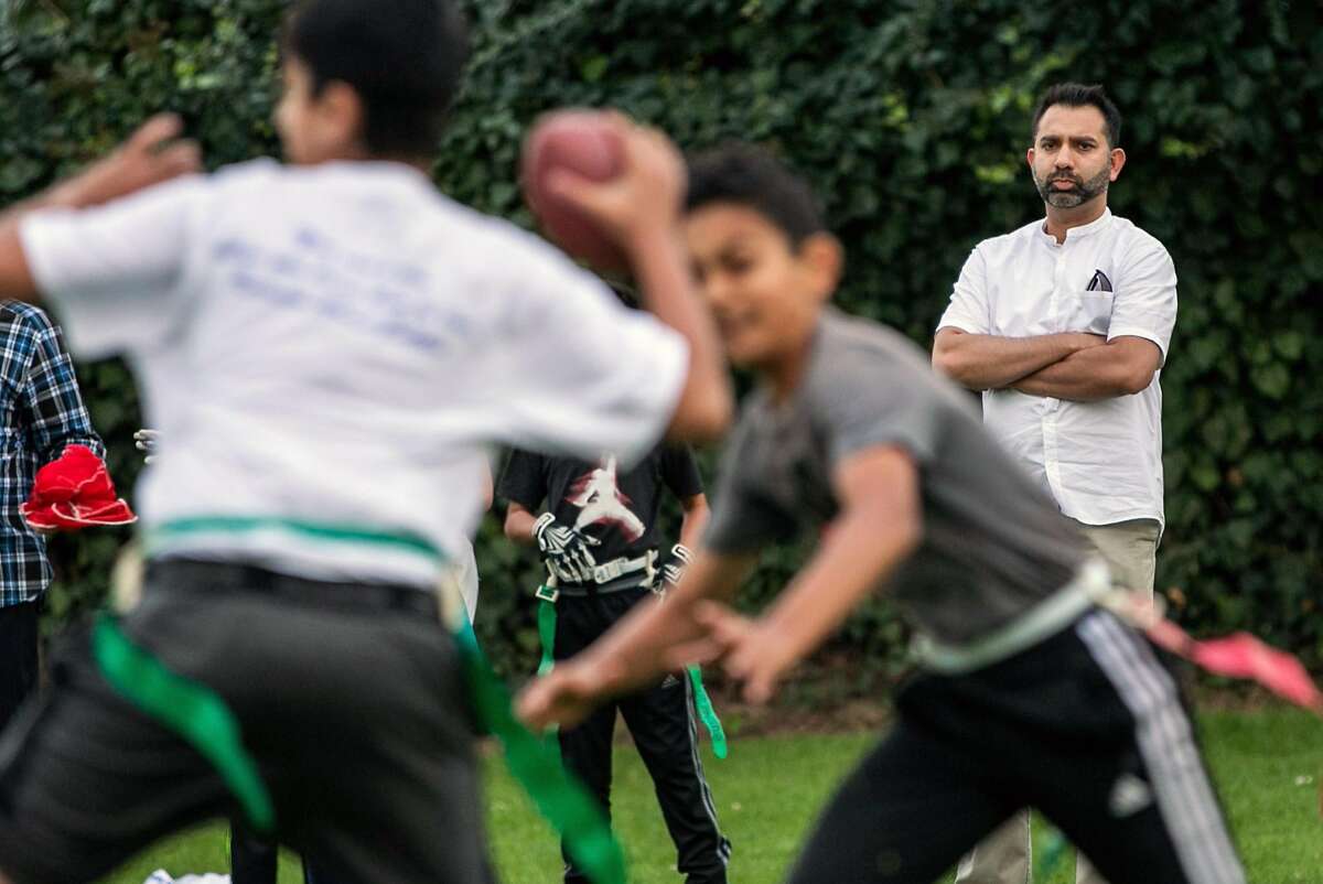 Right: Noman Munif checks out the flag football game, during the Northstar Ilm Tree Sports Day on Friday, Nov. 11, 2016 in Union City, Calif. His sons participate in the games.