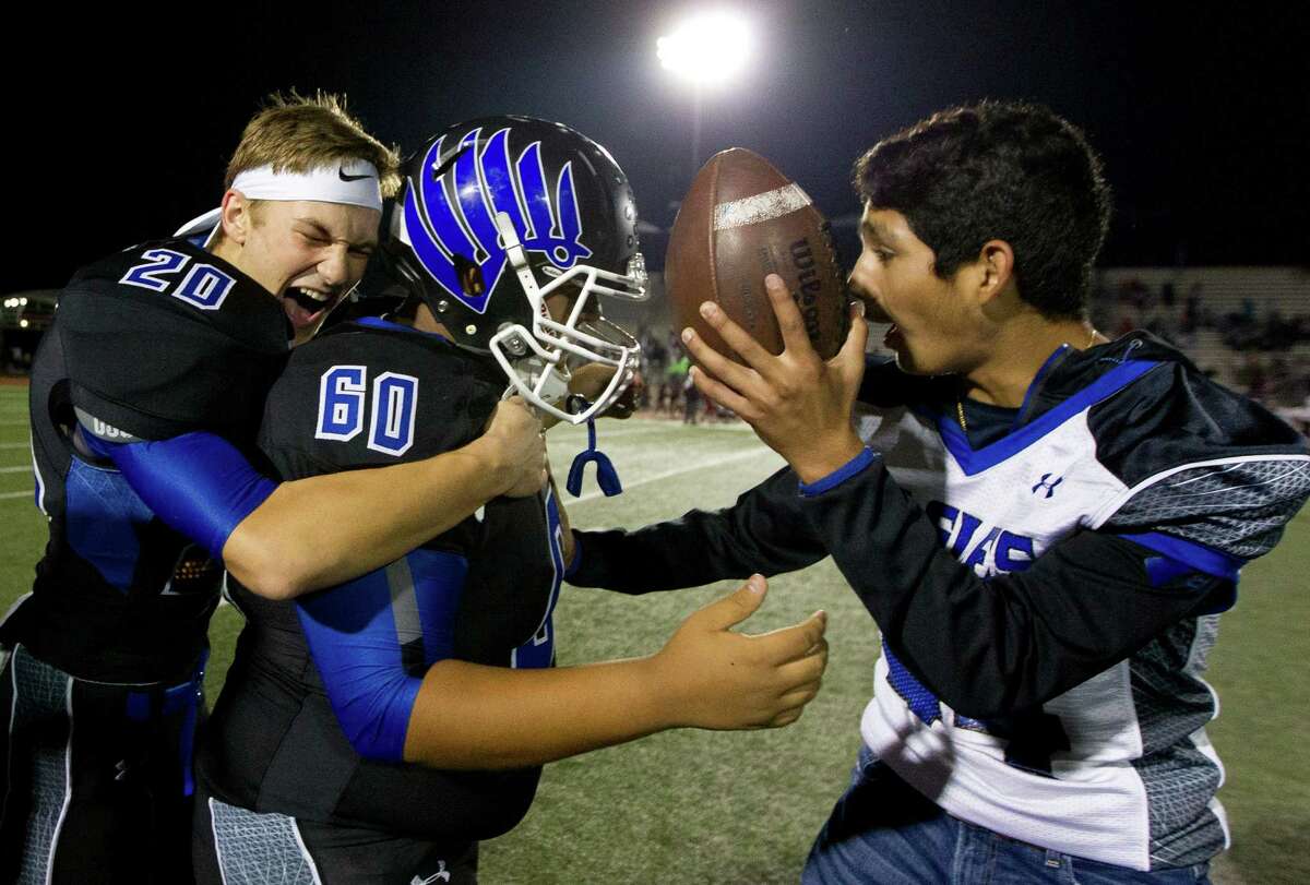New Caney's Mason Vaughn (20) hugs kicker Jason Gonzalez (60) as he is presented with the game ball after kicking 26-yard field goal to give the Eagles a 31-28 triple-overtime win over Beaumont Central in a Region III-5A Division 1 bi-district high school football game at Turner Stadium Saturday, Nov. 12, 2016, in Humble.