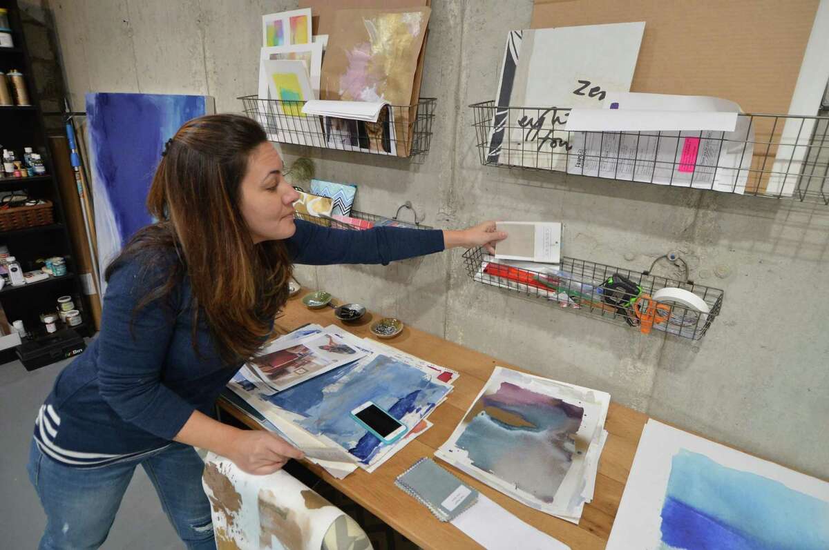 Artist Julia Contacessi grabs some color swatches from a client in her studio on Tuesday November 1, 2016 in Norwalk Conn
