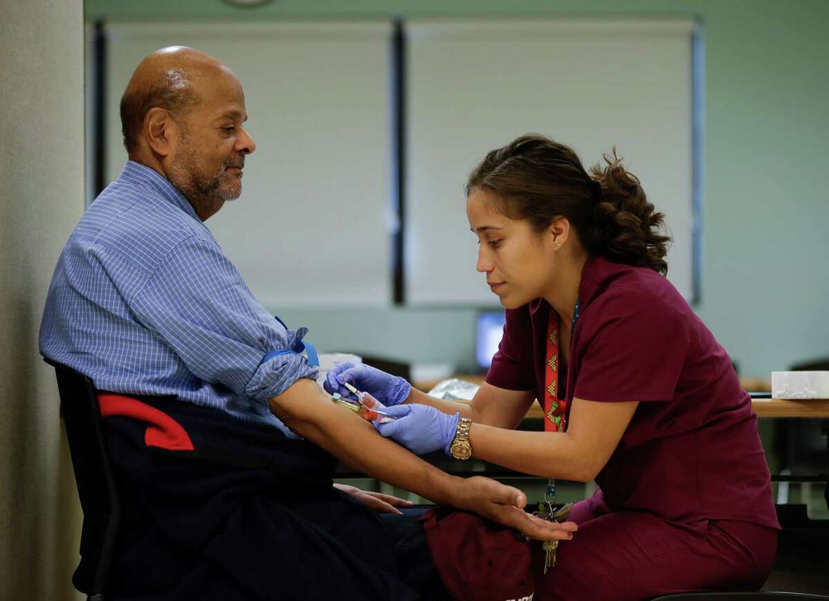 In this Thursday, Nov. 3, 2016, photo, medical assistant Jennifer Martinez draws blood from Joshua Smith that will be tested for PFOS levels in Newburgh, N.Y. State officials recently launched an ambitious effort to offer blood tests to Newburgh's about 28,000 residents after the chemical PFOS  used for years in firefighting foam at the nearby military air base  was found in the city's drinking water reservoir at levels exceeding federal guidelines. (AP Photo/Mike Groll) ORG XMIT: NYMG401
