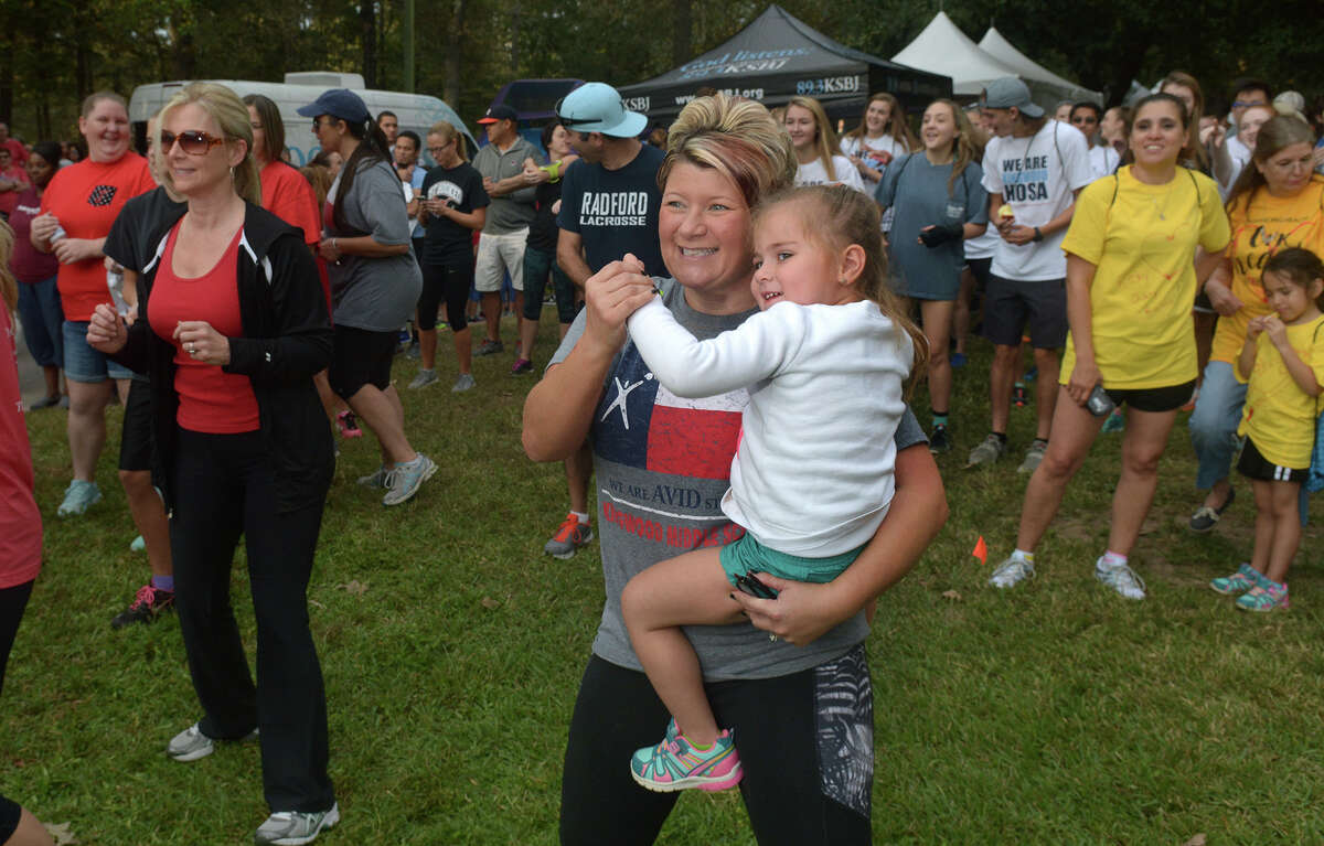 Alicia Rosen, a Kingwood Middle School 6th grade teacher, and her daughter Audrey, 3, join in the warm-up before the start of the Greater Lake Houston Heart Walk at Lone Star College - Kingwood on Nov. 5, 2016. (Photo by Jerry Baker/Freelance)