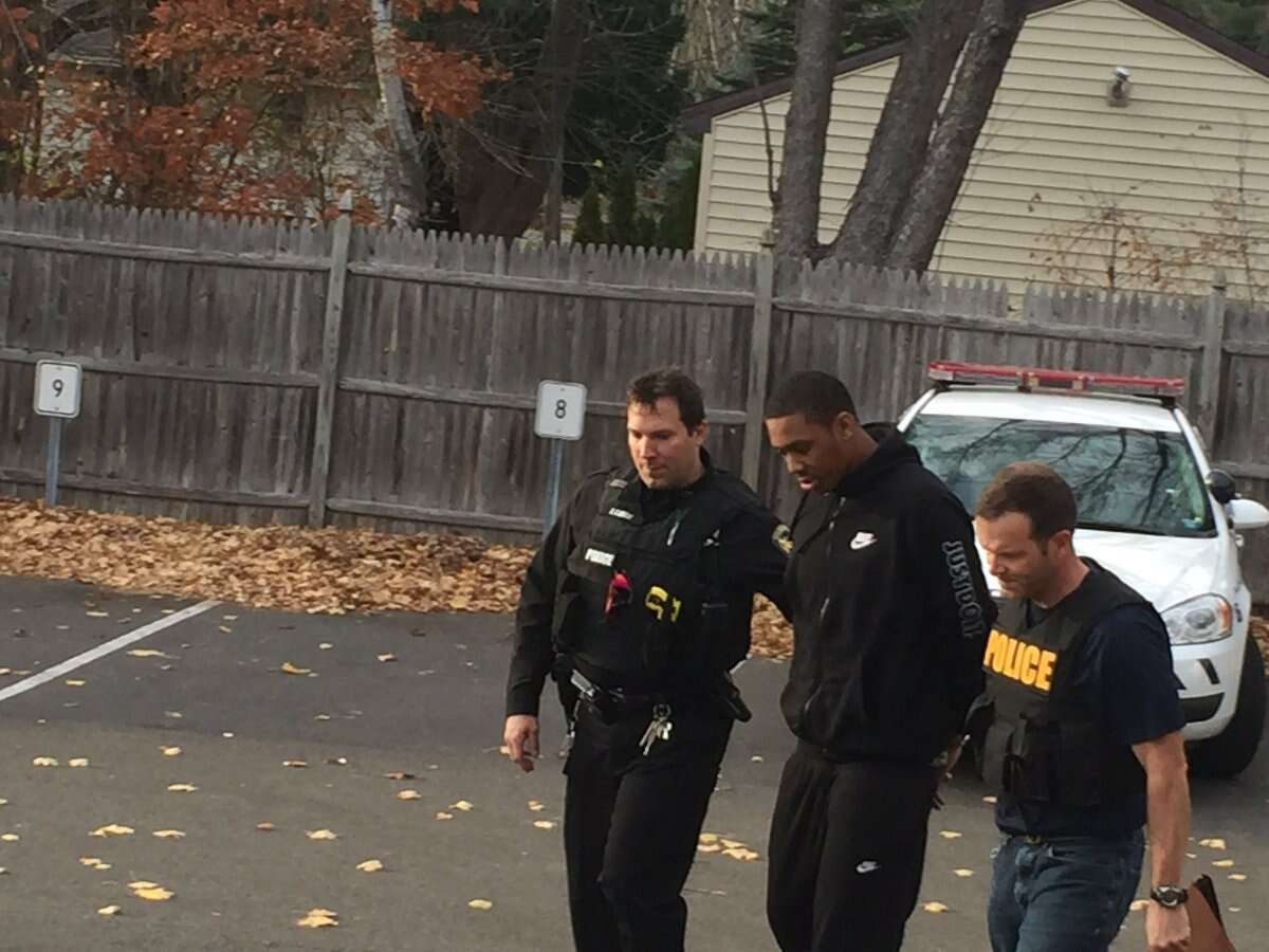 Guilderland Police officers escort a suspect in Saturday's gunfire at Crossgates into the Guilderland police station Monday.