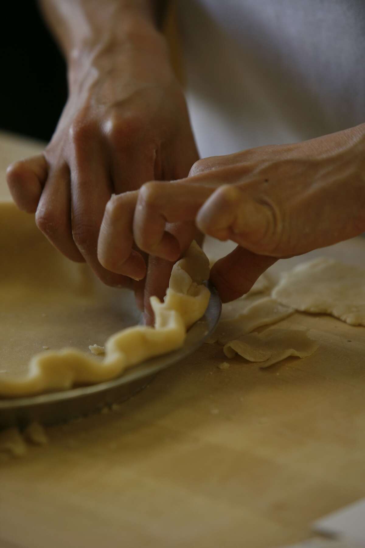 Staff writer Janny Hu crimps the dough for a Best Way Piecrust in the Chronicle test kitchen.