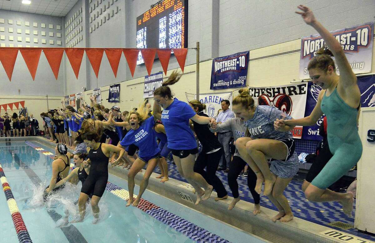 Darien celebrates winning its sixth straight CIAC Class L girls swimming championship at Southern Connecticut State University’s Hutchinson Natatorium in New Haven on Tuesday.