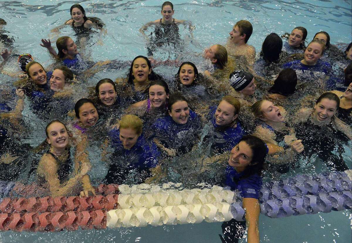 Darien coach Marj Trifone, third from right, celebrates with her team winning a sixth straight CIAC Class L girls swimming championships at Southern Connecticut State University’s Hutchinson Natatorium in New Haven on Tuesday.
