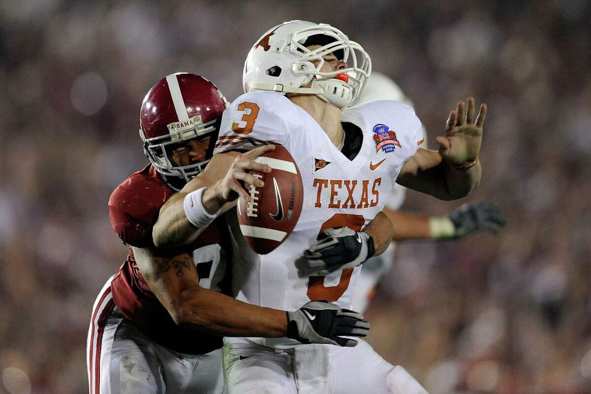 Quarterback Garrett Gilbert of the Texas Longhorns fumbles the ball as he is hit by linebacker Eryk Anders of the Alabama Crimson Tide during the BCS national championship game at the Rose Bowl on Jan. 7, 2010 in Pasadena, Calif.