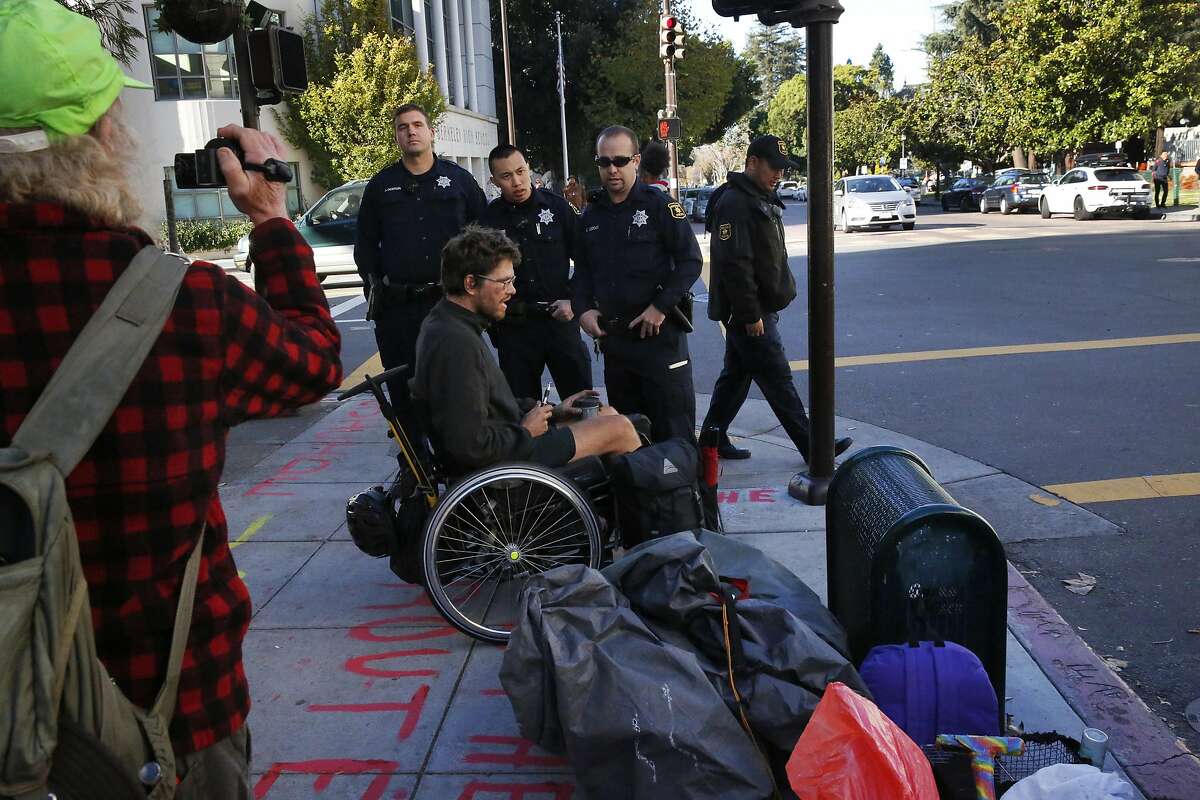 Berkeley Police officers tell Ben and other members of the homeless camp "First they Came for the Homeless" that they cannot block a sidewalk outside of the US Postal Office on Allston Way after they police officers removed the camp earlier in the morning from their spot across the street Nov. 17, 2016 in downtown Berkeley, Calif. The group of homeless were moved by the Berkeley Police Department from the lawn where they had been camping outside of the Martin Luther King Jr. Civic Center early on Thursday morning. The encampment, which calls itself "First they Came for the Homeless" has been protesting the Berkeley food and housing project for weeks.