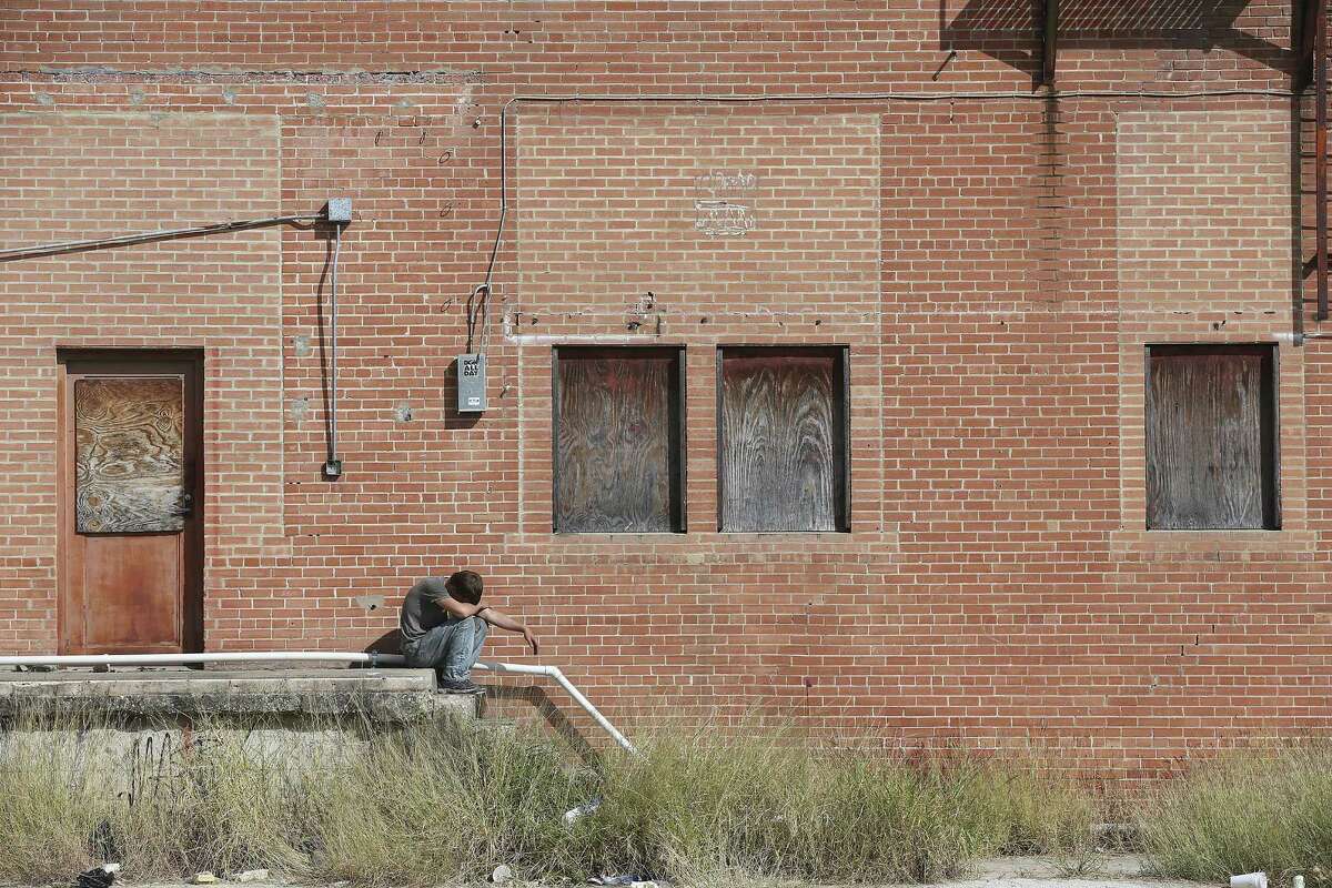 A man sits by the abandoned Scobey building on North Medina Street, Sunday, Oct. 30, 2016. The city took taking members of its housing bond committee on a Saturday bus tour of 12 of the 15 sites where the city could invest millions of dollars for affordable and mixed-income housing. The city is considering its first housing bond ever, a $20 million initiative that will be on the ballot in May. But many officials fear there won't be enough support for the bond, and already there's concern that members of the housing bond committee itself oppose spending the money for this purpose.