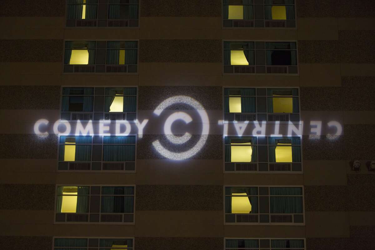 MANCHESTER, NH - FEBRUARY 05: The Comedy Central logo projected on the side of the Radisson Hotel before Comedy Central's 'The Daily Show with Trevor Noah' Presents 'Podium Pandemonium: A Debate About Debates,' New Hampshire Primary 2016 off-air event & post-reception on February 5, 2016 in Manchester, New Hampshire. Scroll ahead to see classic photos taken at the Chronicle Comedy Day in Golden Gate Park in 1987.