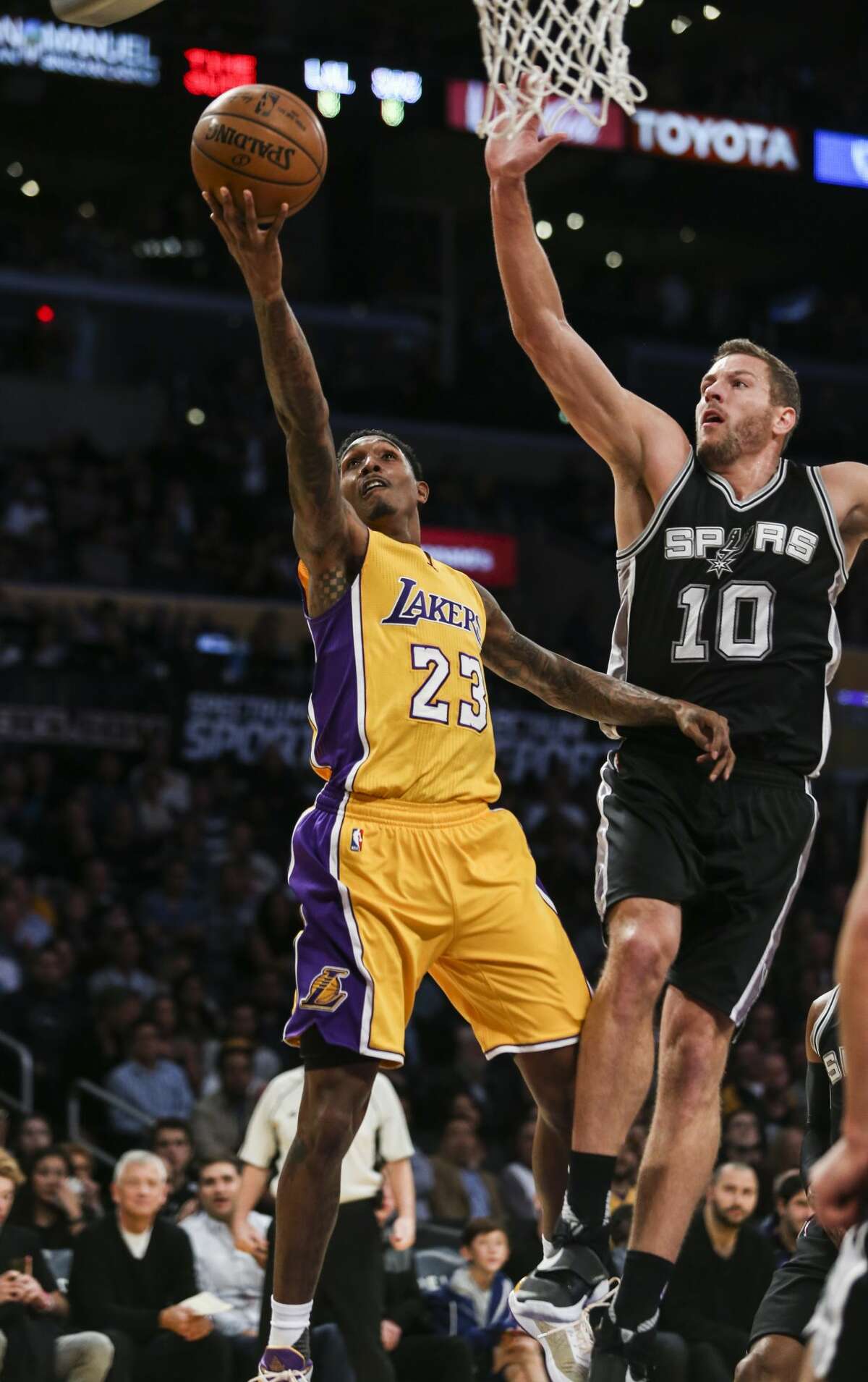 Los Angeles Lakers guard Lou Williams goes up for a layup while defended by San Antonio Spurs forward David Lee during the first half of an NBA basketball game Friday, November 18, 2016, in Los Angeles. (AP Photo/Ringo H.W. Chiu)