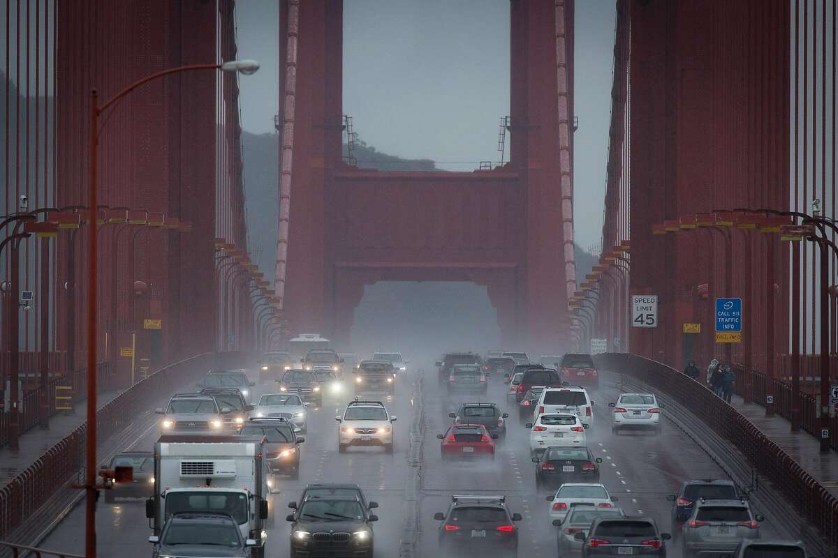 Cars make a slow drive across the Golden Gate while rain falls throughout the Bay Area.