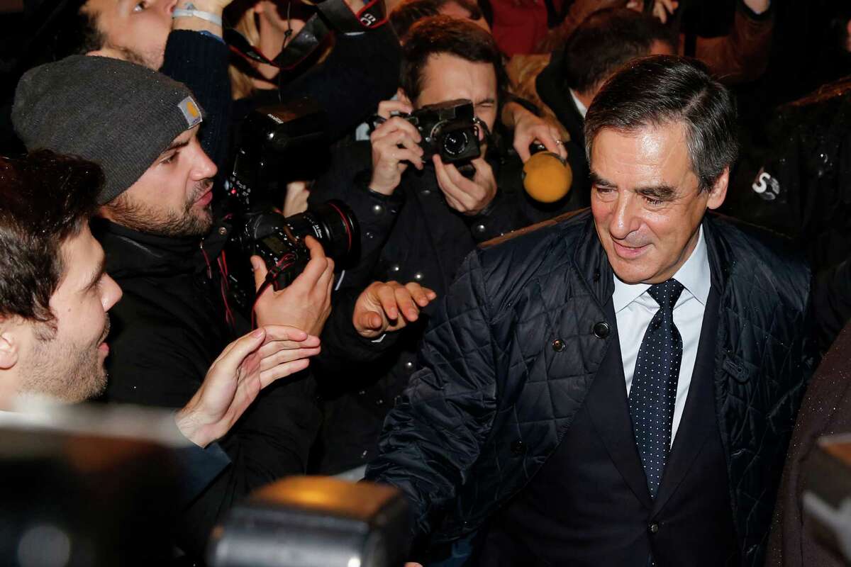 Candidate for the right-wing Les Republicains (LR) party primaries ahead of the 2017 presidential election and former French prime minister, Francois Fillon, right, arrives at his campaign headquarters after the vote's first round, on November 20, 2016 in Paris. on Sunday, Nov. 20, 2016. Francois Fillon had the largest share of votes in early returns Sunday from the first round of the conservative primary for next year's presidential election. (Gonzalo Fuentes/Pool Photo via AP)