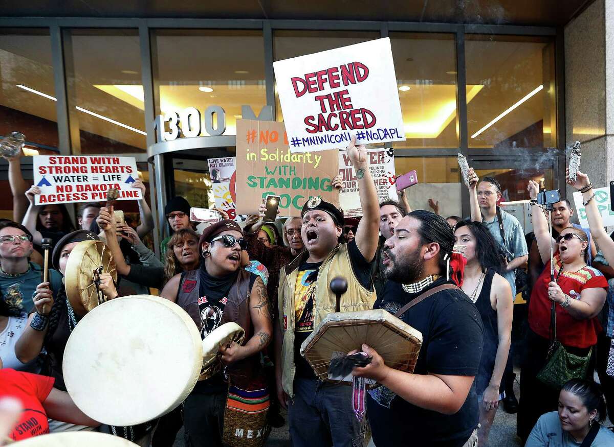 Oscar Gonzalez with Houston Stands for Standing Rock leads protesters in a song during a peaceful Dakota Access Pipeline protest in front of 1300 Main Street Tuesday,Nov. 15, 2016 in Houston. Two people were arrested as the protest was winding down for verbally abusing police and a bystander. ( Karen Warren / Houston Chronicle )